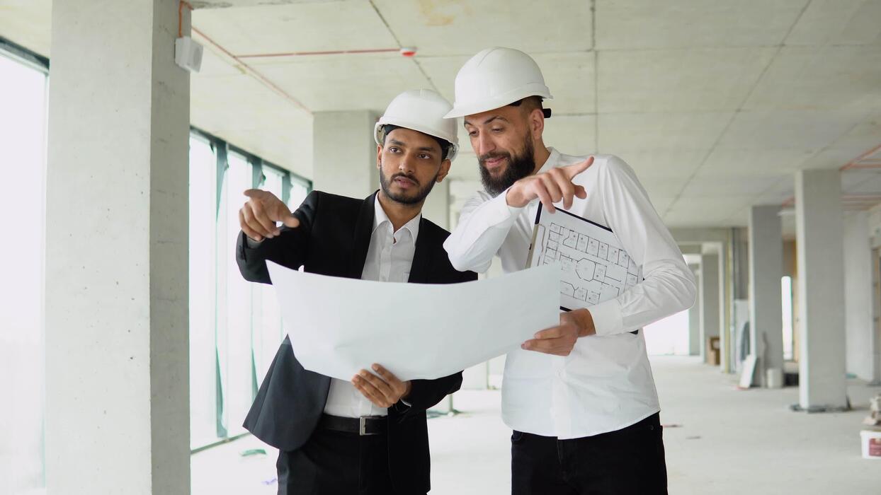 Técnico supervisando la ejecución de una reforma junto a los operarios en la obra