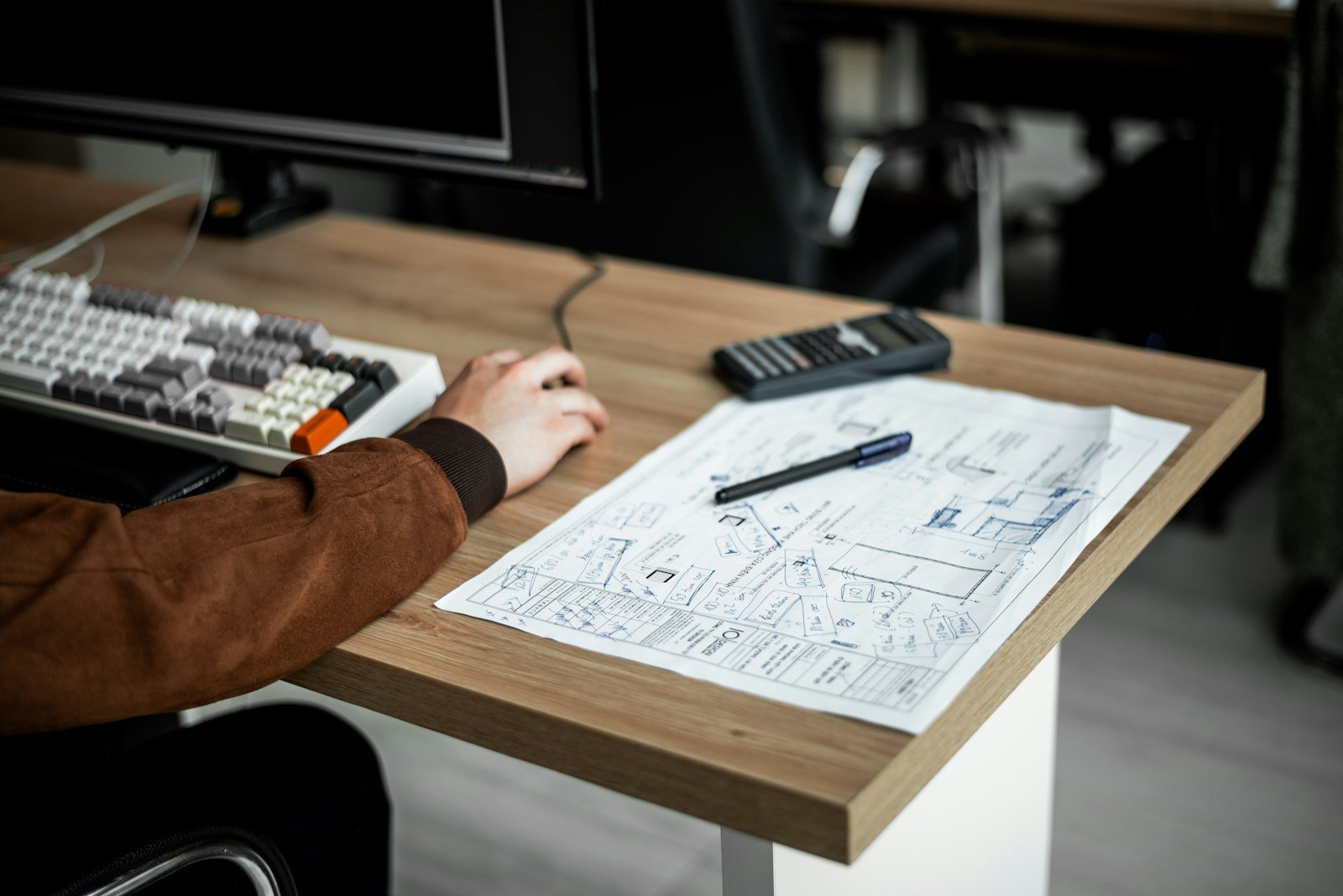 El proceso completo de diseñar una casa a medida – Imagen 1 Mesa de arquitecto con planos y maqueta de una vivienda unifamiliar en fase de proyecto