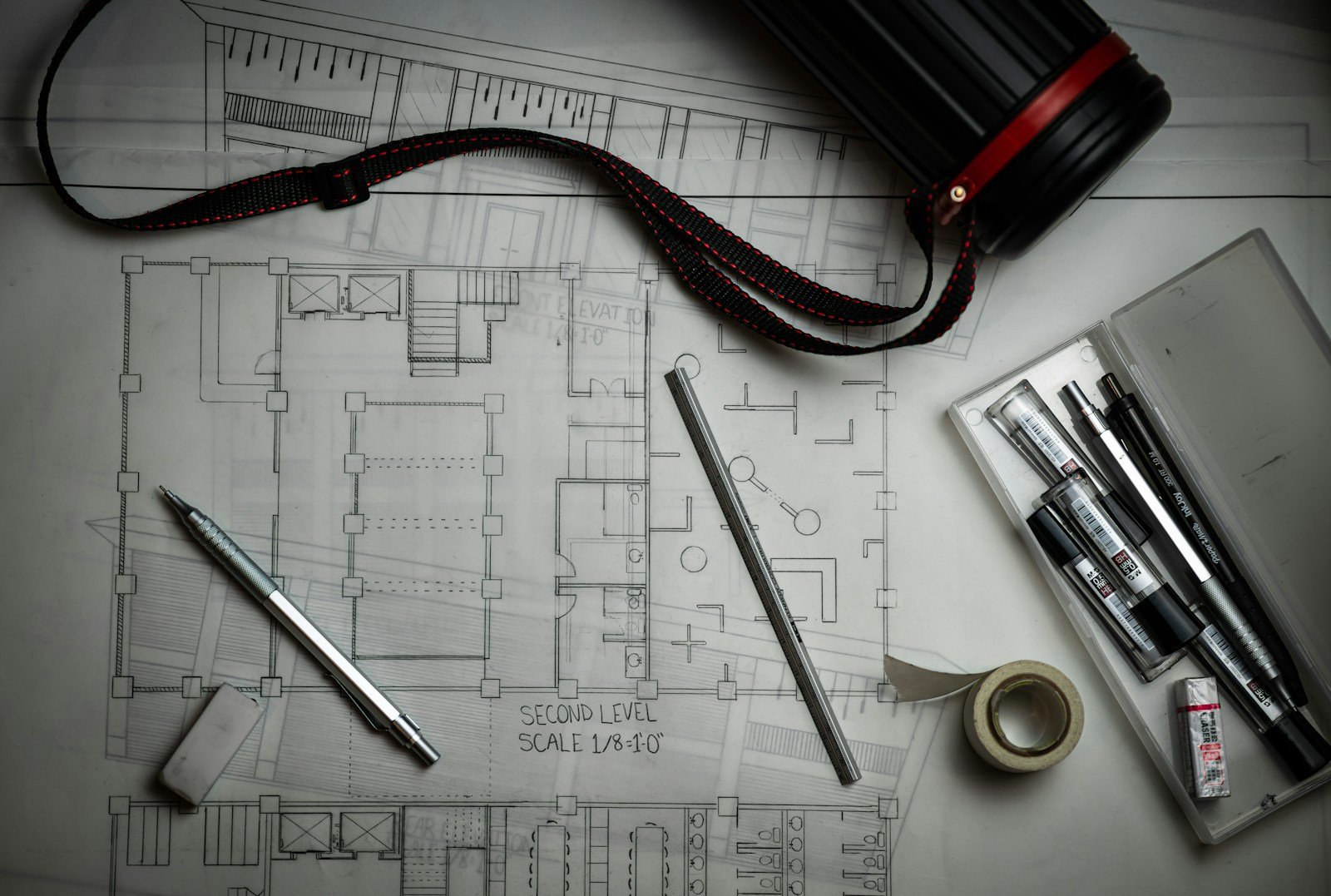 Planos de distribución y muestras de materiales sobre mesa de estudio de interiorismo