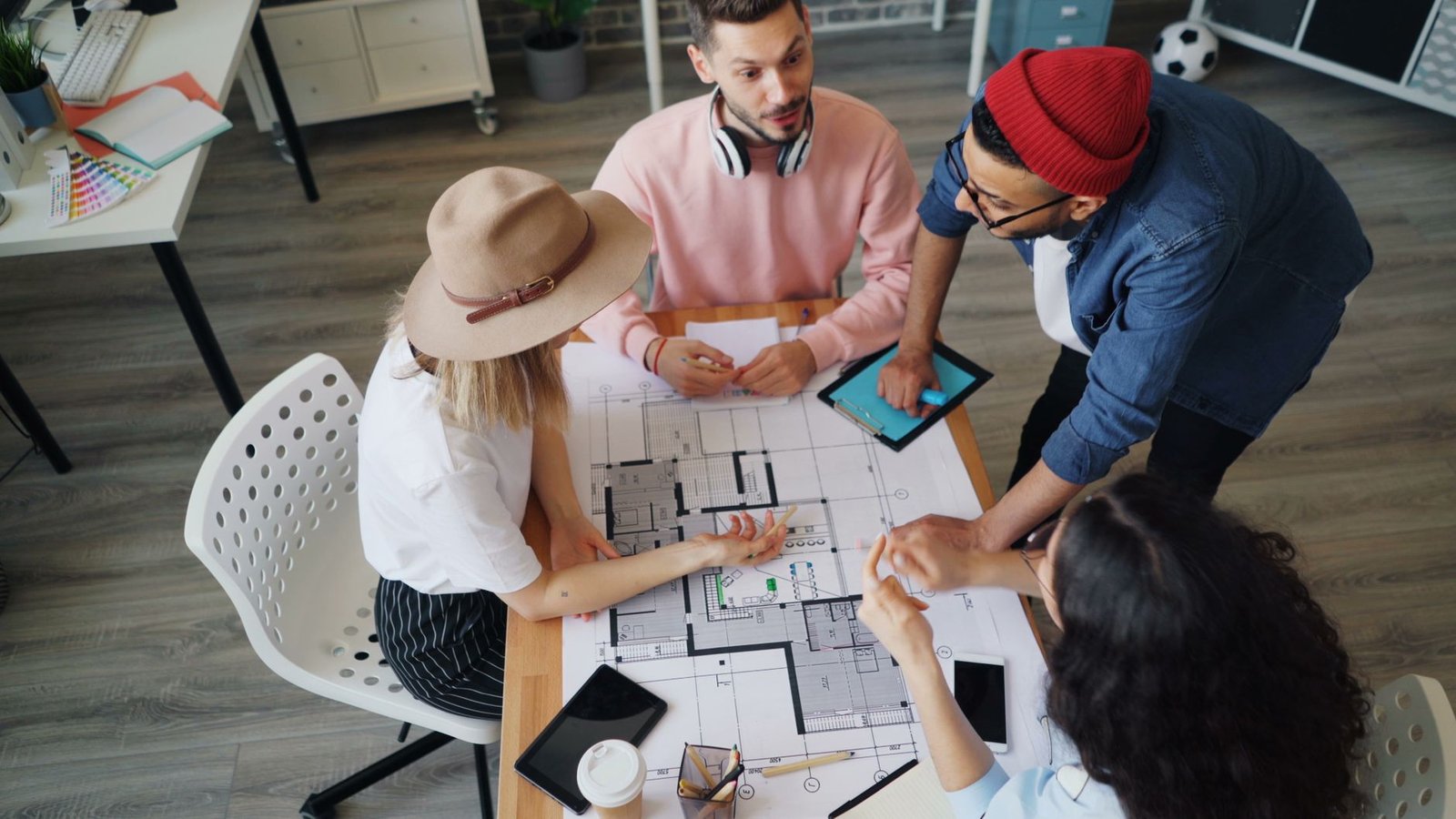 Taller de diseño participativo con planos y notas sobre la mesa de trabajo